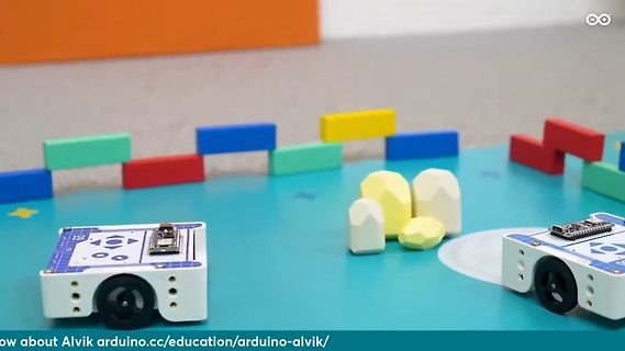 Zwei kleine Roboter auf einem Spielteppich