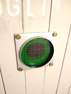 Grünes Runddisplay an Holzpaneel