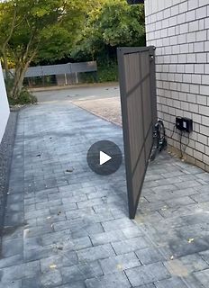 Ein graues Metalltor vor einer Ziegelwand