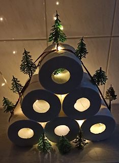 Weihnachtsbaum aus Toilettenpapierrollen mit Lichterkette und Tannenbäumen