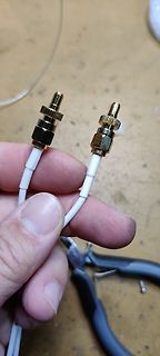Zwei goldene Cinch-Stecker an weißem Kabel