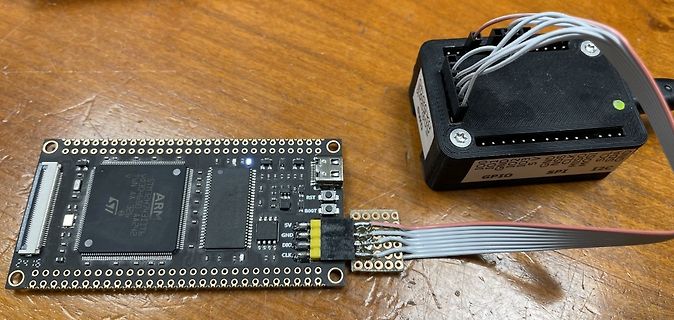 Mikrocontroller-Platine mit Flachbandkabeln auf Holztisch