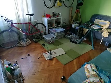 Unordnung in einem Zimmer mit Fahrrad und Elektronikbauteilen