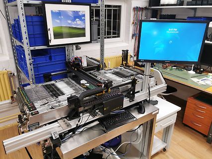Testaufbau mit Computer, Monitor und Hardware-Komponenten