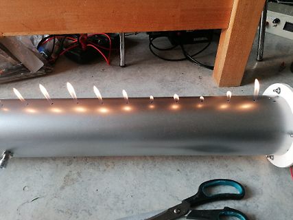 Metallrohr mit brennenden Löchern auf Werkstattboden