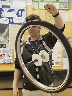 Mann hält ein rotierendes Rad an einer Schnur