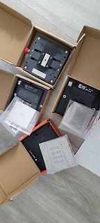 Mehrere schwarze Platinen in Kartons und Plastikverpackungen