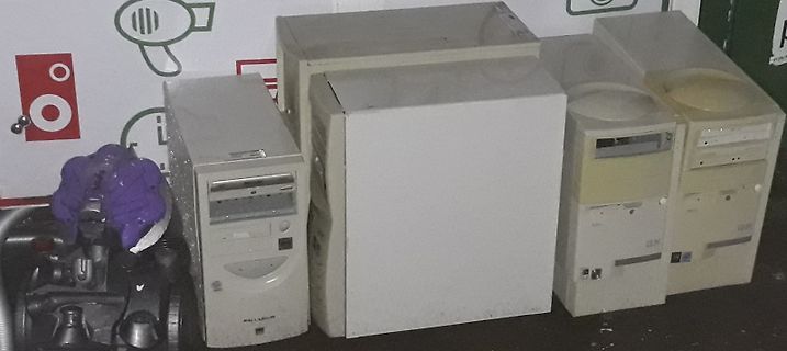 Mehrere alte Computergehäuse und ein Staubsauger