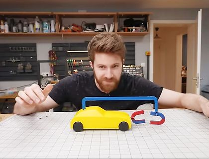 Mann mit gelbem Spielzeugauto und Magneten