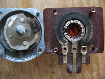 Zwei zerlegte Potentiometer auf Holzuntergrund