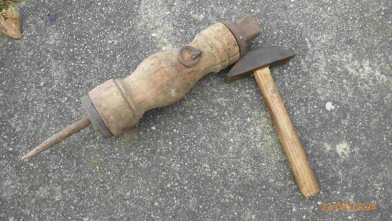 Holzwerkzeug und Hammer auf Asphalt