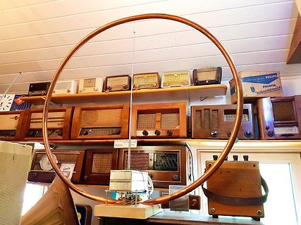 Große Kupferspule vor alten Radios