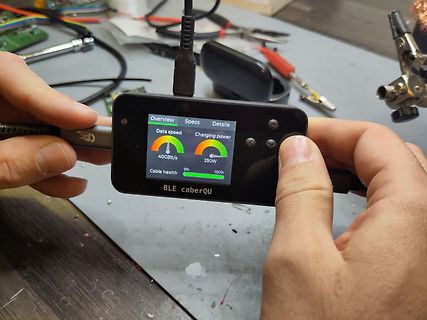 Hand hält USB-C-Messgerät mit Display