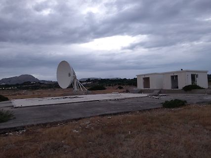 Satellitenschüssel und Gebäude unter bewölktem Himmel