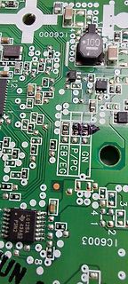 Nahaufnahme einer grünen Leiterplatte mit elektronischen Bauteilen