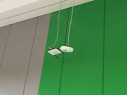 Zwei kleine Sensoren oder Module an Kabeln vor grünem Hintergrund