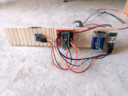 Elektronik-Aufbau mit Arduino und Batterie auf Holzbrett