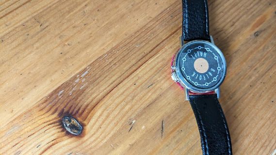 Rückseite einer Armbanduhr auf Holzuntergrund
