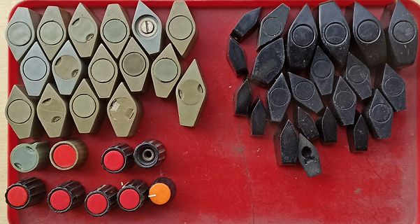 Diverse Bauteile und Drehregler auf rotem Untergrund