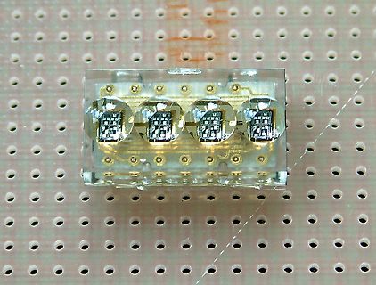 Vier in Epoxidharz eingegossene Mikrochips auf Lochrasterplatte