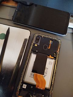 Zerlegtes Smartphone mit freigelegter Batterie und Flexkabel