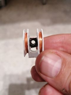 Kleine Spule mit Kupferdraht in der Hand