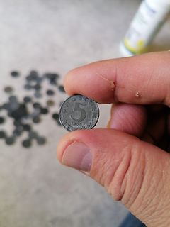 Hand hält eine 5 Pfennig Münze