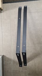 Zwei schwarze Metallwinkel an einer gefliesten Wand