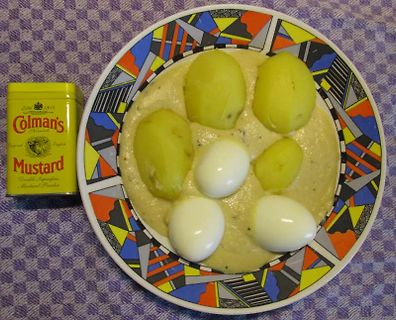 Teller mit Kartoffeln, Eiern und Senf