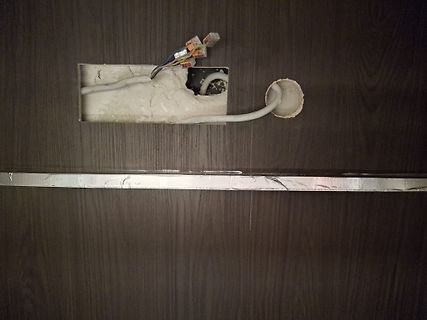 Freiliegende elektrische Kabel und eine Unterputzdose in einer Wand