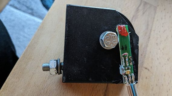 Schwarzer Block mit Schraube und kleiner Platine