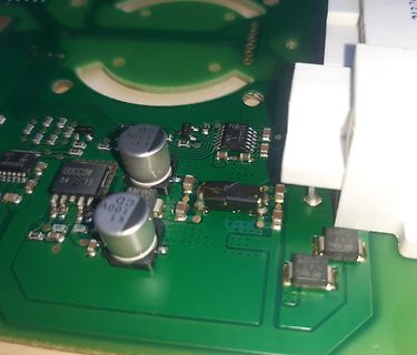 Nahaufnahme einer Leiterplatte mit Elektrolytkondensatoren und ICs