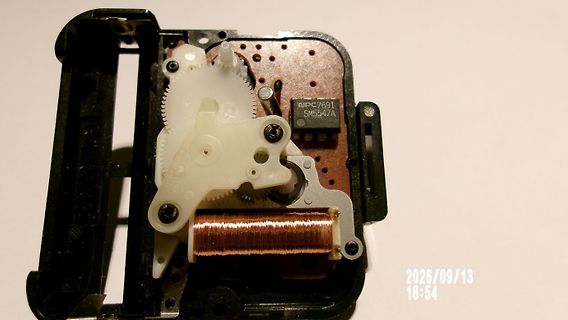 Innenansicht eines mechanischen Bauteils mit Zahnrädern und Spule