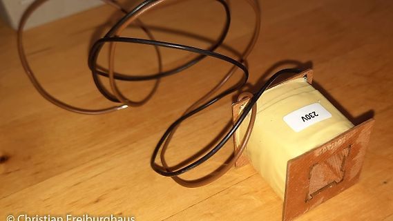 Transformator mit Kabeln auf Holztisch