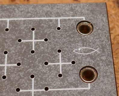 Detailaufnahme einer Leiterplatte mit Bohrungen und Symbolen