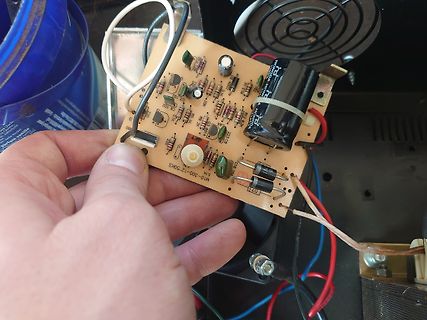 Hand hält Leiterplatte eines Netzteils