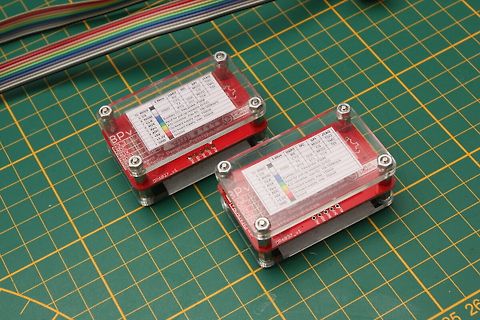 Zwei rote Leiterplatten in Acrylgehäusen auf Schneidematte