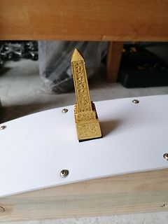 Goldene Obelisk-Miniatur auf weißem Untergrund