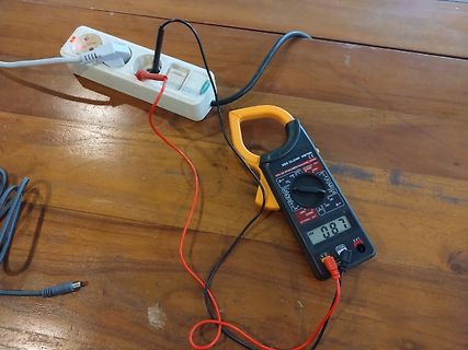Multimeter misst Spannung an Steckdose