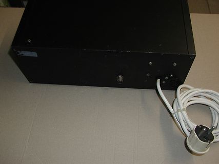 Rückseite eines schwarzen Netzteils mit Netzkabel