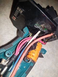 Innenansicht eines geöffneten Elektrogeräts mit Kabeln und Kondensator