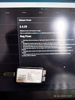 Foto eines Logikanalysators und Software-Release-Notes auf einem Bildschirm