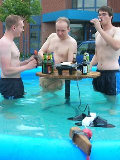 Drei Männer trinken Bier in einem Pool