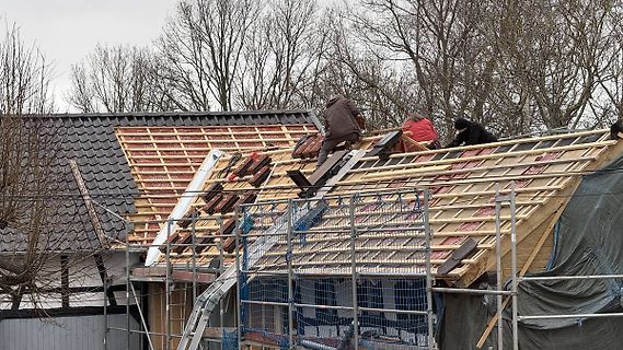 Dachdecker bei Dacharbeiten am Hausdach