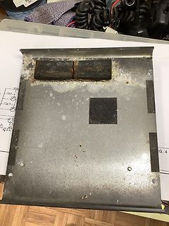 Metallplatte mit zwei schwarzen Bauteilen