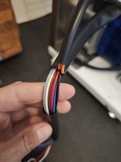 Bunte Kabel eines Netzteils in der Hand