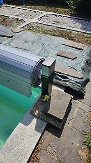 Pool mit Abdeckrolle und Steinen