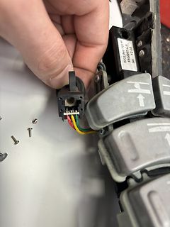 Hand hält elektrischen Stecker an Schaltermodul