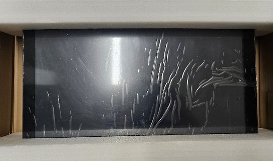 Foto einer schwarzen, reflektierenden Oberfläche in einer Verpackung