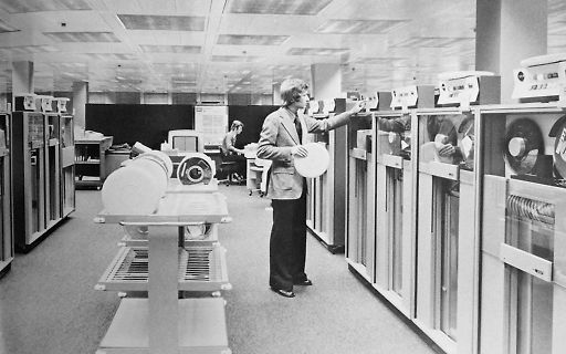 Person in Rechenzentrum mit Magnetbandspulen